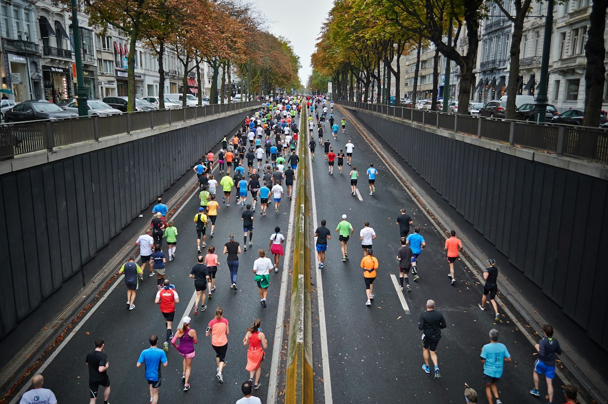 Marathon runner crossing finish line on city pavement celebrating remarkable health transformation