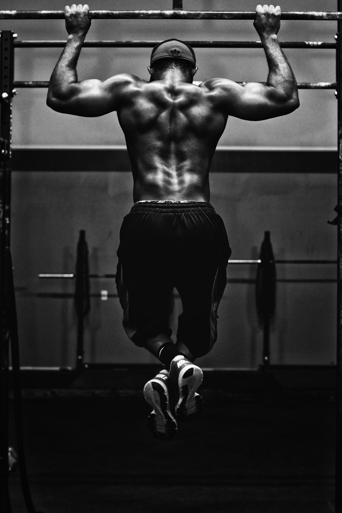 Strength athlete gripping heavy barbell on lifting platform showing rehabilitated spine and posterior power