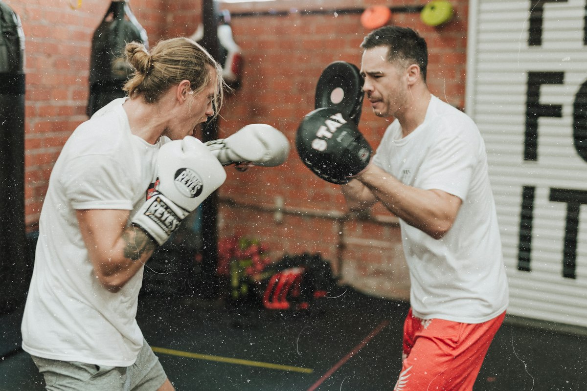 Focused female martial arts fighter wrapping hands in boxing gym preparing for high intensity sparring