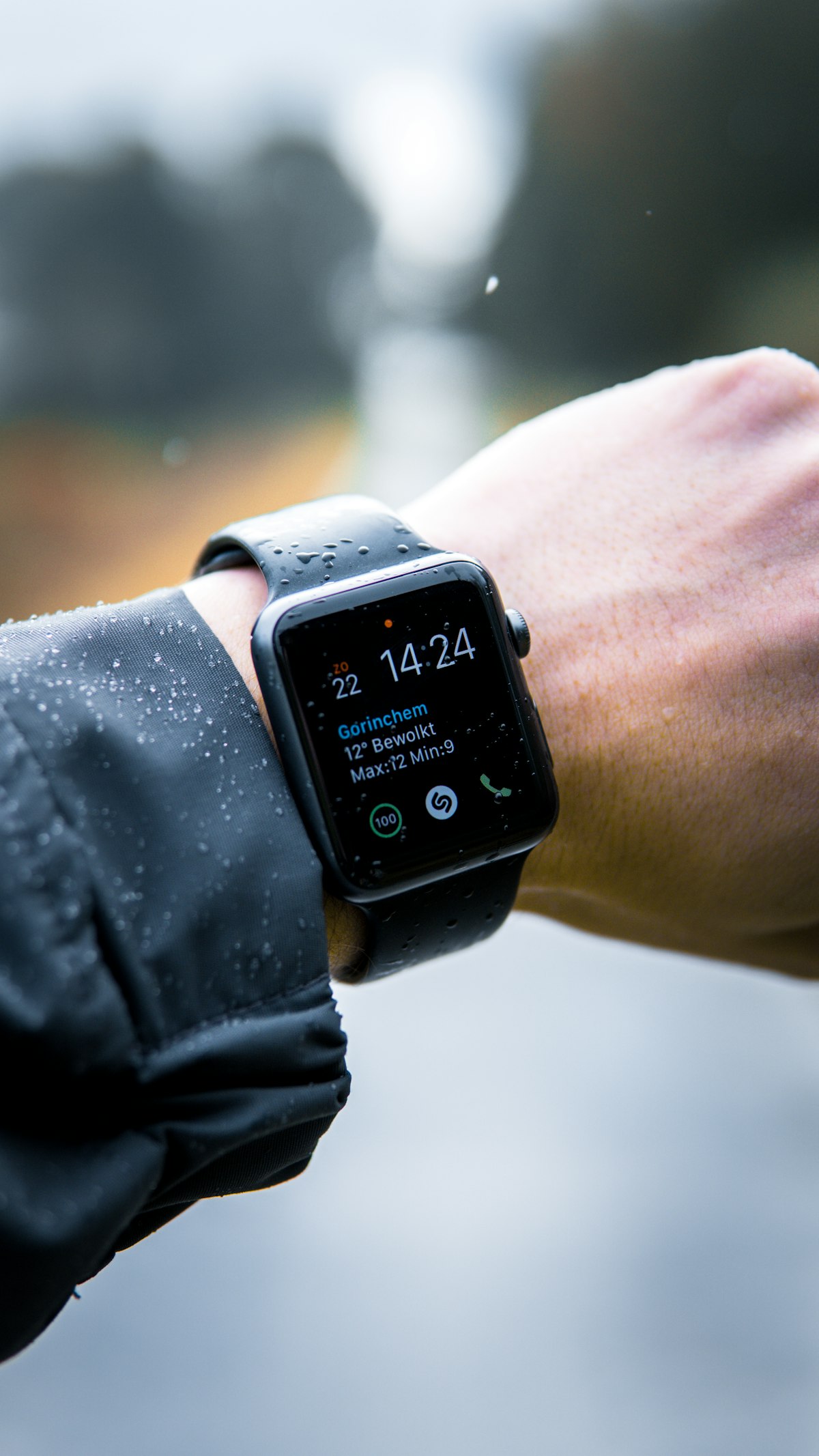 Athlete checking high-end GPS running smartwatch displaying heart rate zones during outdoor trail training